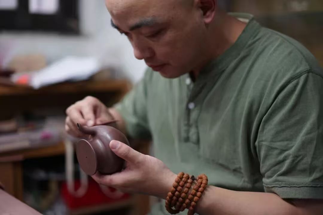 Master Xiang Feng carving a teapot