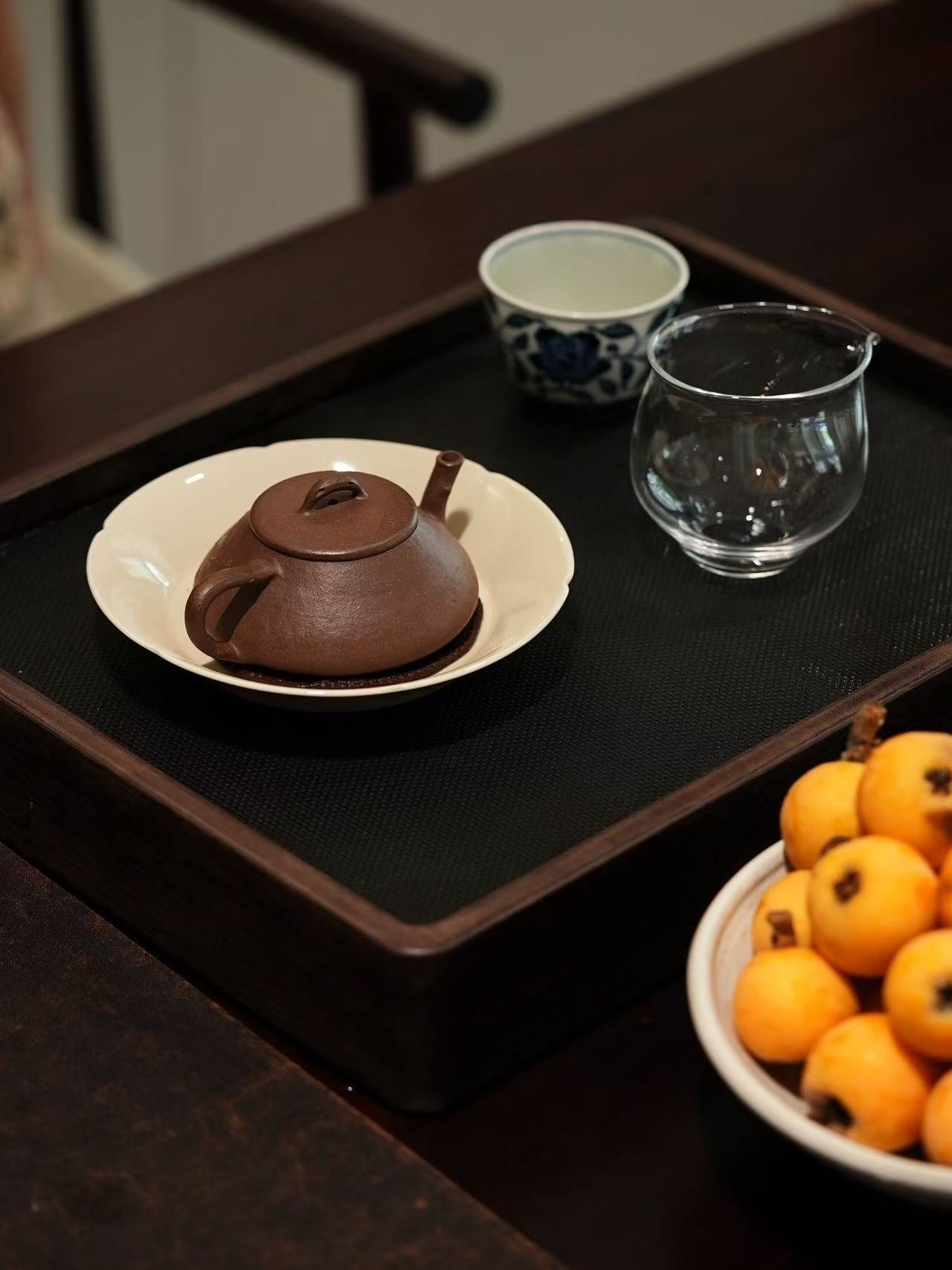 A teapot on a tray with loquats